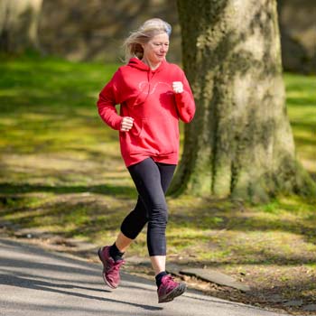 Eine ältere Frau joggt im Park